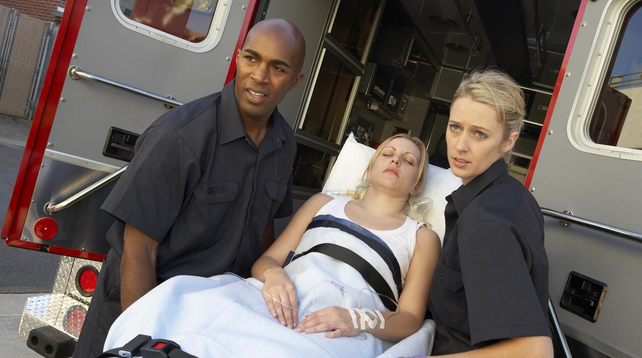 Two EMTs load woman into ambulance