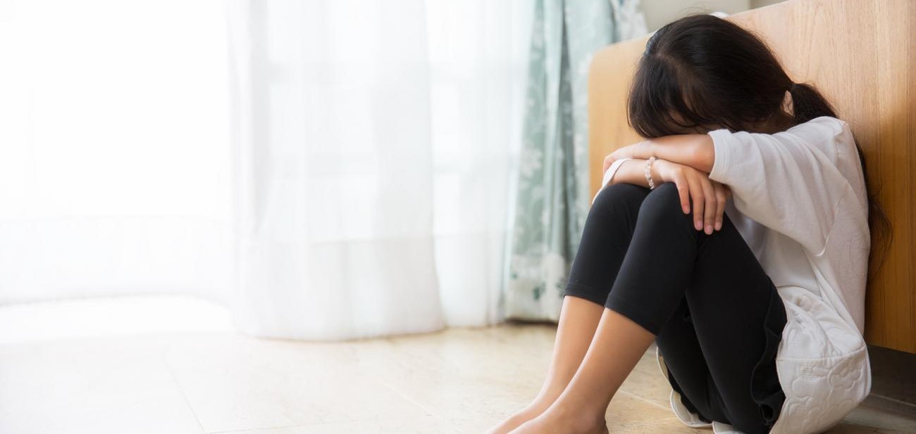 Girl sitting with her head in her arms