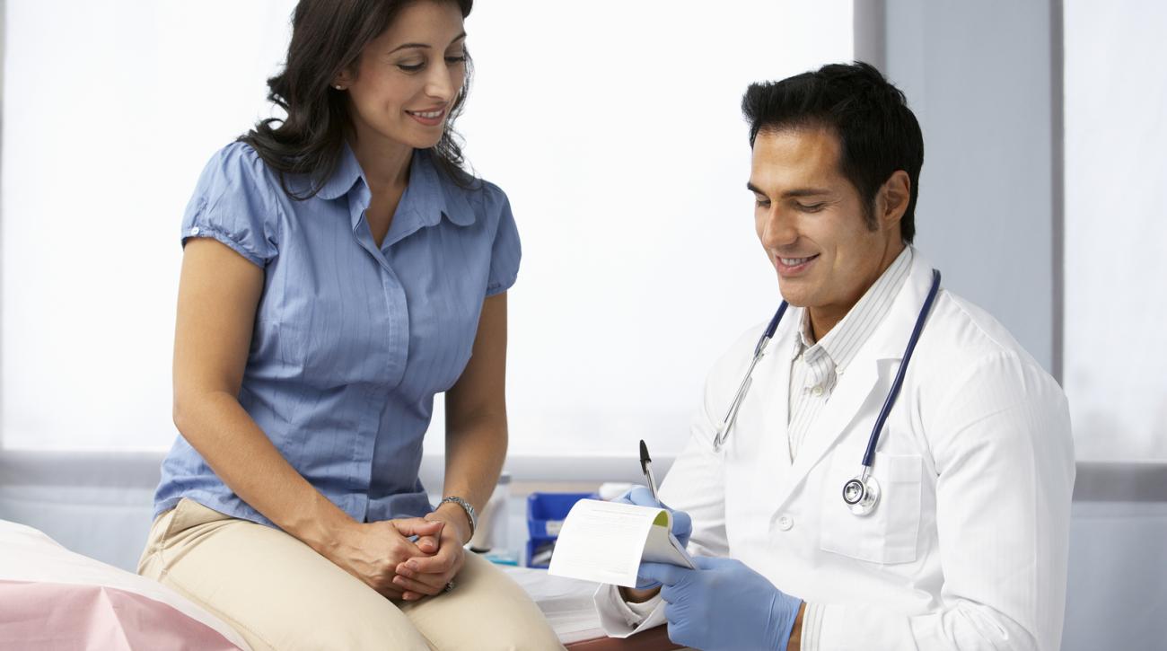 Doctor writing prescription for female patient