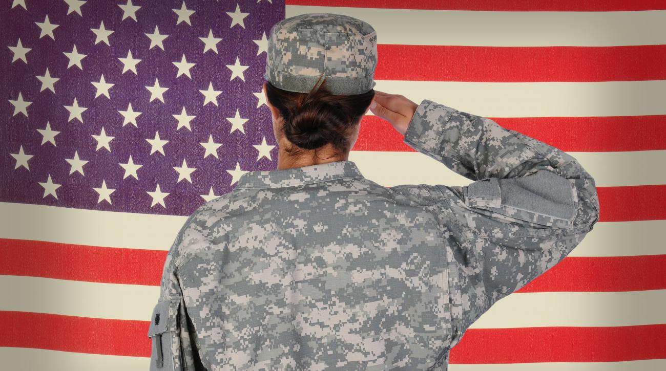 female soldier in front of American flag