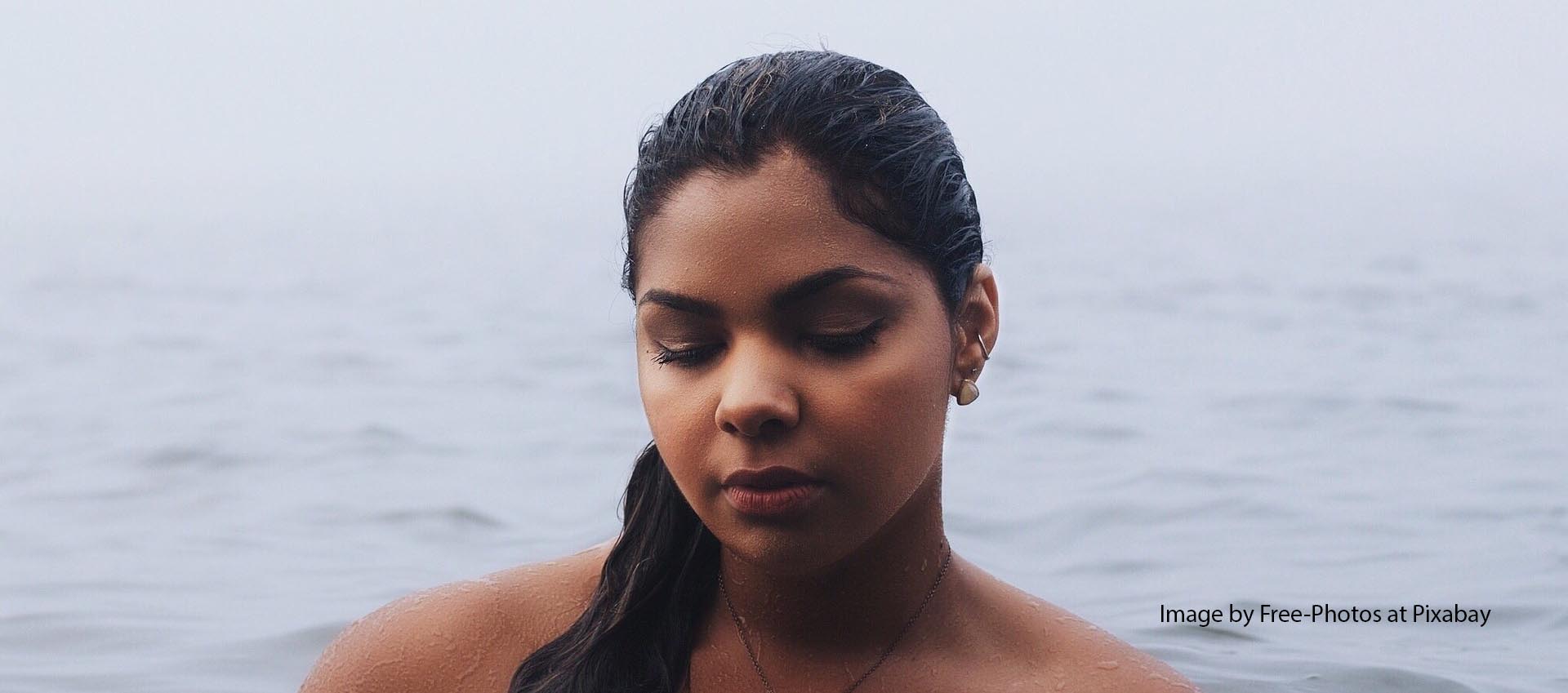 Woman standing in a body of water and looking anxious