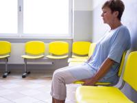 Woman sitting alone in waiting room, looking unhappy