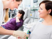 Nurse assists woman seated in a medical setting
