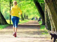 Woman jogging on path surrounded by trees