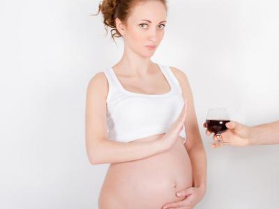 Pregnant woman pushes away glass of wine being offered