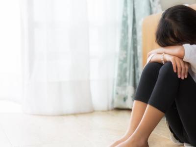 Girl sitting with her head in her arms