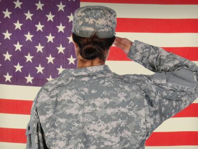 female soldier in front of American flag