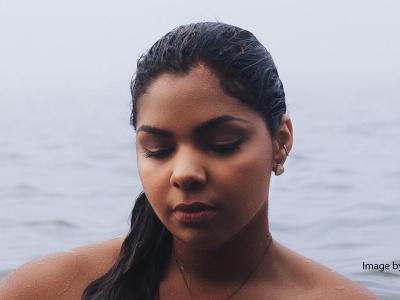 Woman standing in a body of water and looking anxious