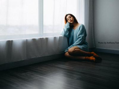 Woman leaning on a window looking sad