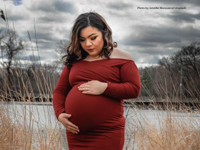 Pregnant Latina with clouds behind her