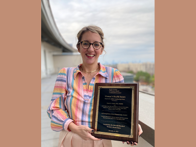 Sara Redd holds Gibbs Prize plaque