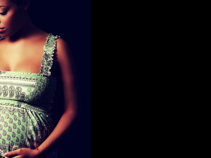 Pregnant woman holding belly and head